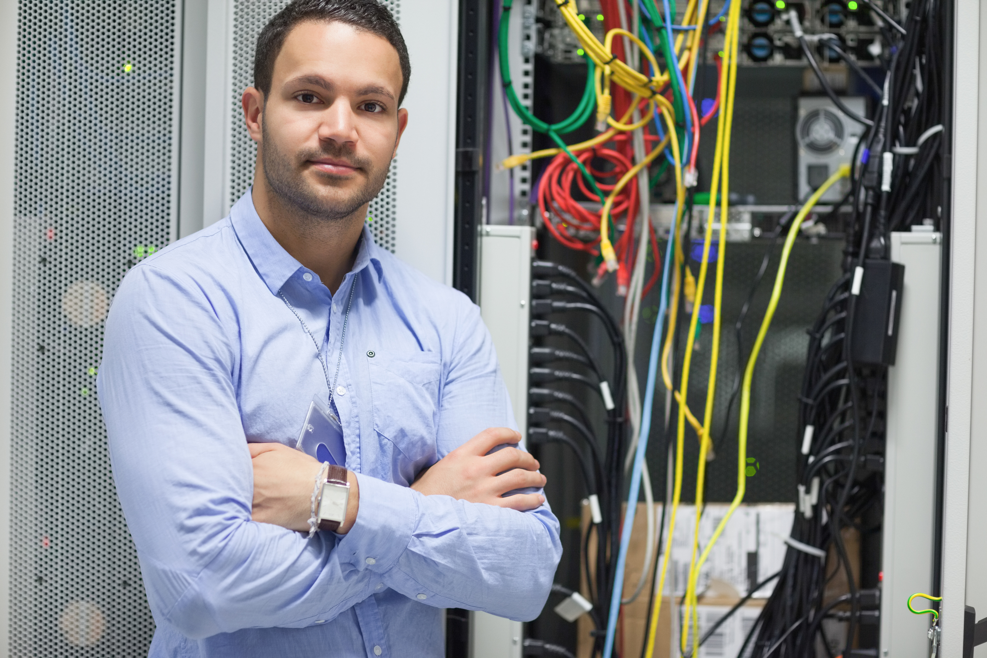 Man standing with arms crossed in data center